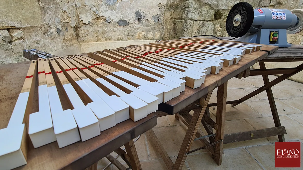 Polissage des ivoires des touches sur un piano ancien