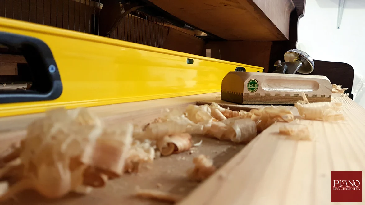 Dégauchissage au rabot du plateau de clavier sur un piano ancien PLEYEL